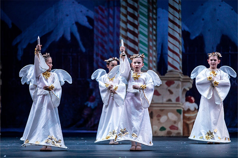 Dancers holding candles as angels in The Nutcracker.