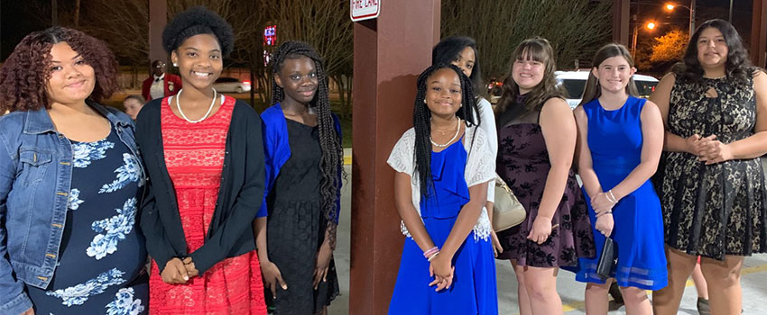 Group of young ladies standing outside a theater<br />
